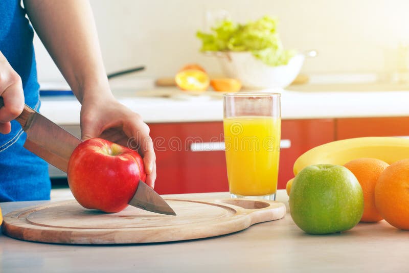 Mains coupant la pomme faisant le jus images libres de droits
