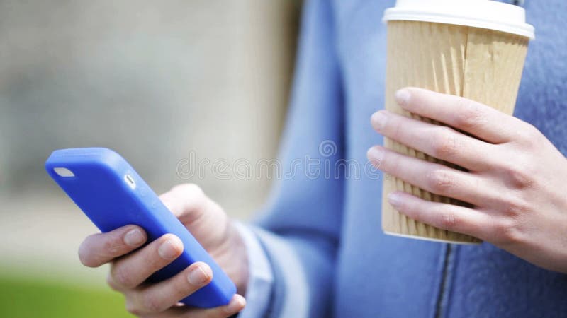 Mains de femme avec la tasse de café et le smartphone clips vidéos