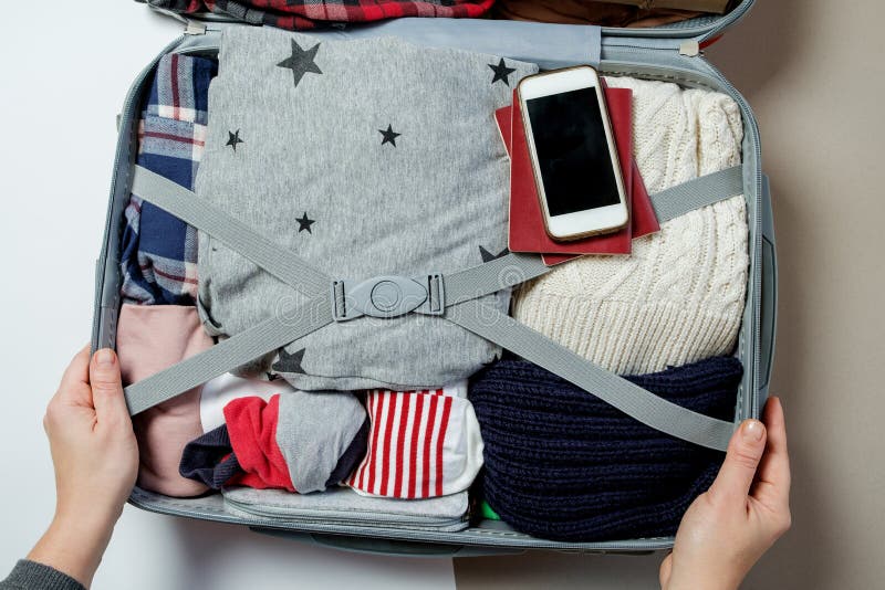 Mains de femme avec le téléphone sur le fond de la valise Open emballé photo libre de droits Mains de femme avec le téléphone sur le fond de la valise Open emballé photo libre de droits