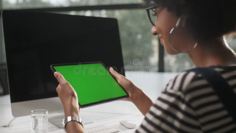Mains de femme d'affaires Internet opérant sur le comprimé sur le bureau. Les mains de fille tiennent le gadhet sur l'écran vert. banque de vidéos