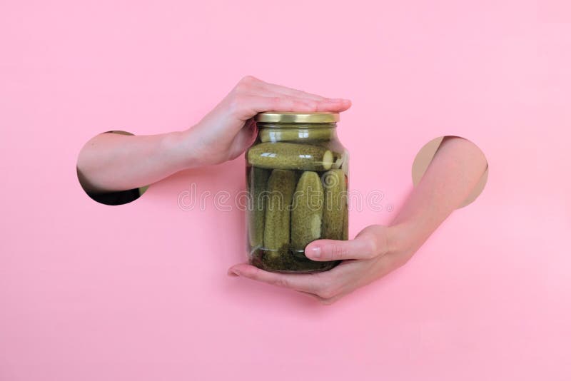 Mains de femme tenant le pot de conserves au vinaigre salées Concombre organique photo stock Mains de femme tenant le pot de conserves au vinaigre salées Concombre organique photo stock