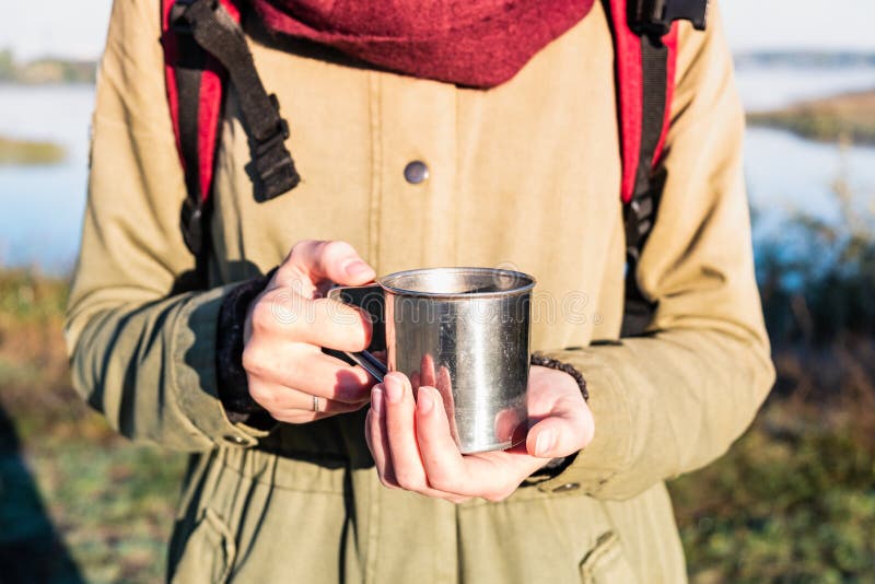 Mains de femme tenant une tasse de cuisson à la vapeur de dans bel enviro de nature photographie stock libre de droits Mains de femme tenant une tasse de cuisson à la vapeur de dans bel enviro de nature photographie stock libre de droits