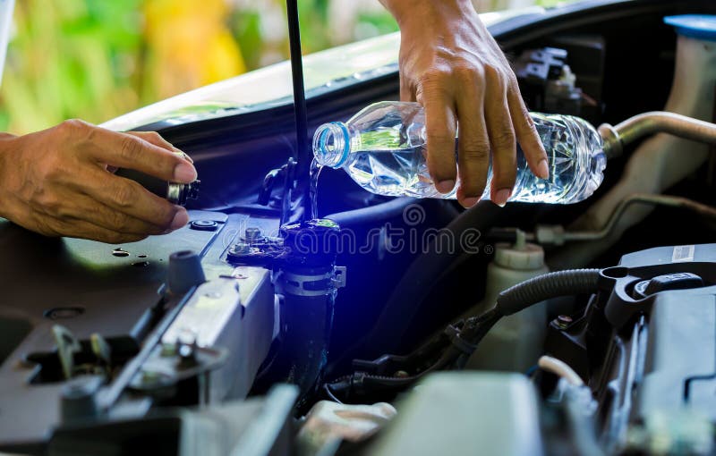 Mains de l'eau de Check de mécanicien dans le radiateur de voiture et ajouter l'eau au radiateur de voiture photo libre de droits Mains de l'eau de Check de mécanicien dans le radiateur de voiture et ajouter l'eau au radiateur de voiture photo libre de droits