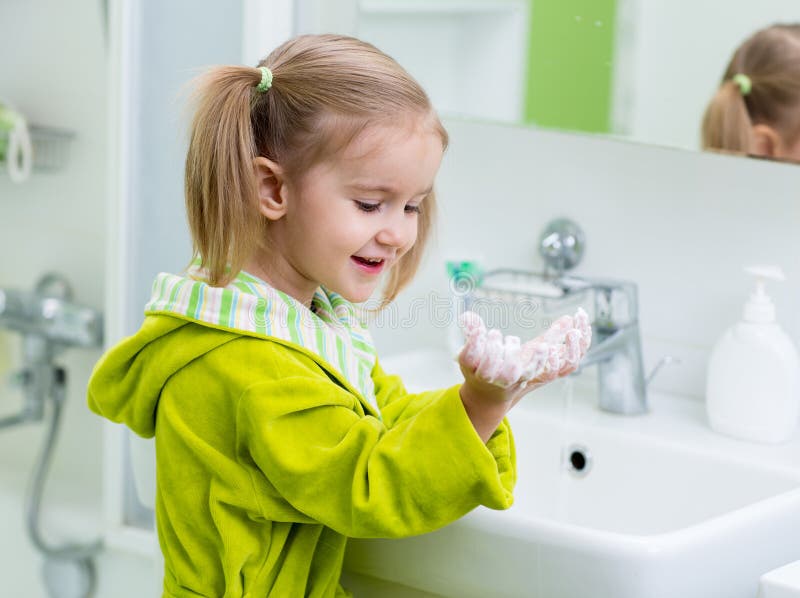 Mains de lavage d'enfant mignon dans la salle de bains photographie stock Mains de lavage d'enfant mignon dans la salle de bains photographie stock