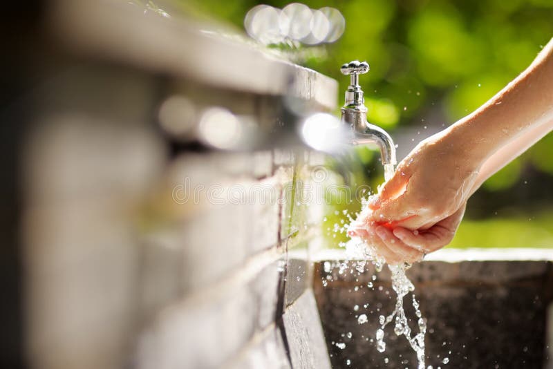 Mains de lavage de femme dans une fontaine de ville photos stock Mains de lavage de femme dans une fontaine de ville photos stock