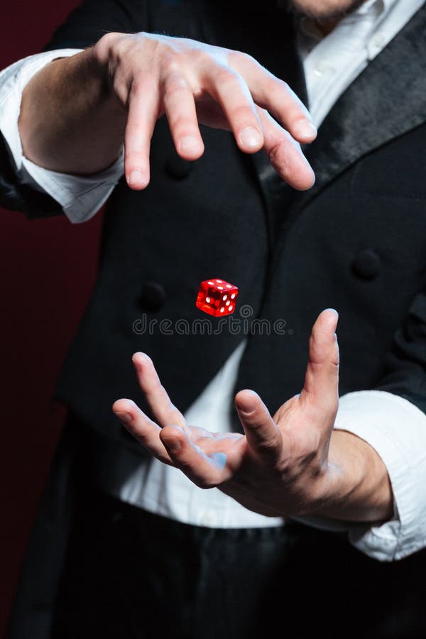 Mains de magicien de l'homme faisant le vol rouge de matrices en air photographie stock Mains de magicien de l'homme faisant le vol rouge de matrices en air photographie stock