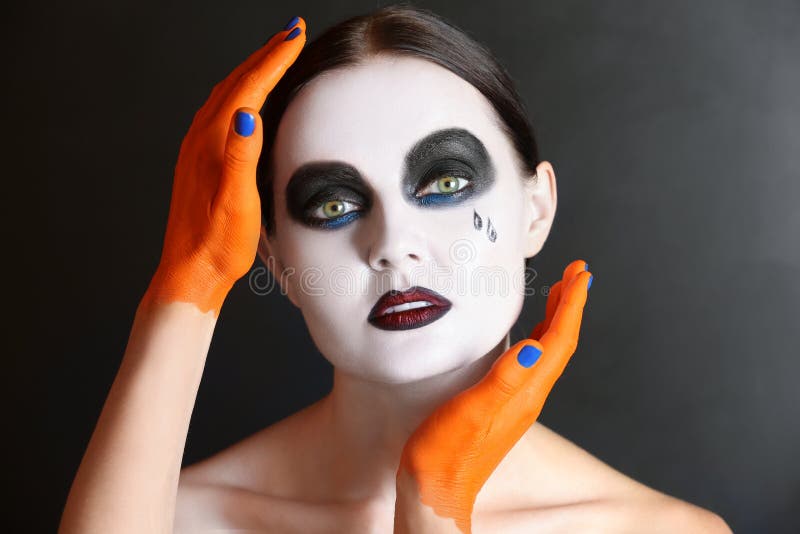 Mains de monstre touchant la jeune femme avec le maquillage de Halloween sur le fond foncé photo libre de droits Mains de monstre touchant la jeune femme avec le maquillage de Halloween sur le fond foncé photo libre de droits