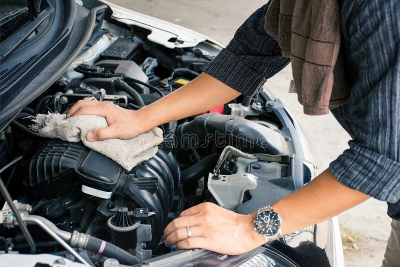 Mains de travailleur d'homme ou de m?canicien automobile nettoyant le moteur de voiture avec le tissu photographie stock libre de droits Mains de travailleur d'homme ou de m?canicien automobile nettoyant le moteur de voiture avec le tissu photographie stock libre de droits
