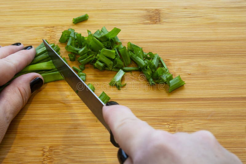 Mains De Femme Couper Les Légumes Sur Le Fond En Bois. Légumes