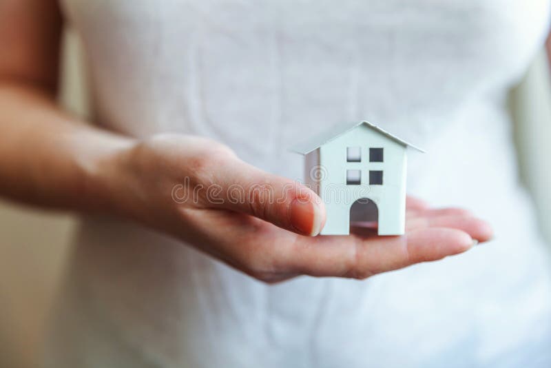 Mains femelles de femme tenant la maison blanche miniature de jouet photo libre de droits Mains femelles de femme tenant la maison blanche miniature de jouet photo libre de droits