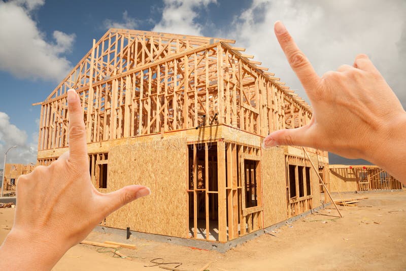 Female Hands Framing New Home Frame on Construction Site. Female Hands Framing New Home Frame on Construction Site.