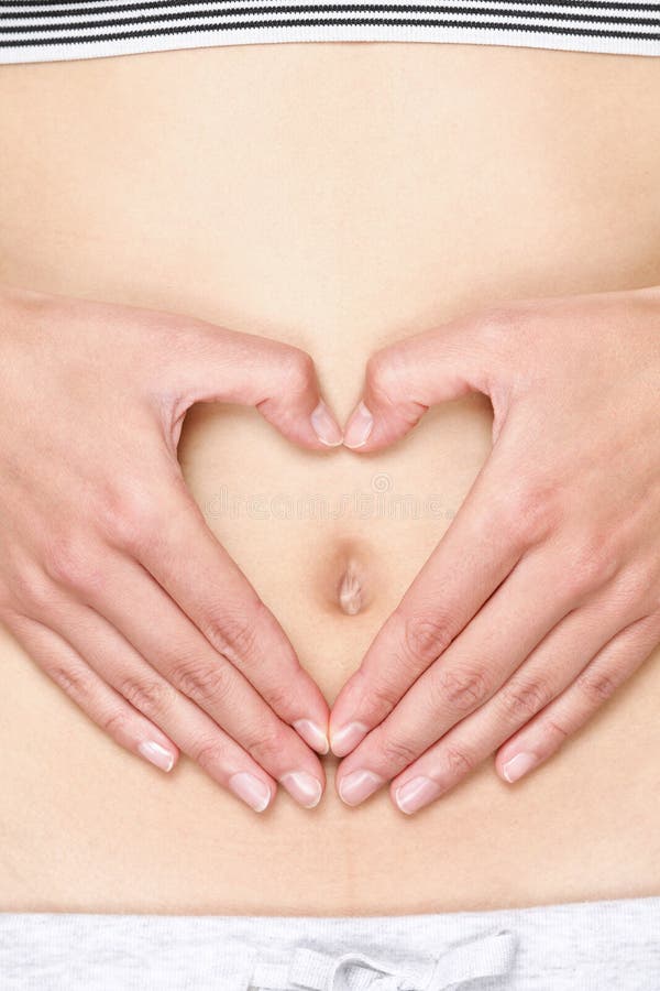Mains formant le coeur sur l'estomac image stock Mains formant le coeur sur l'estomac image stock