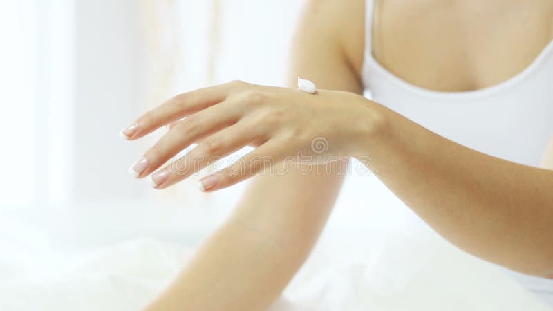 Mains heureuses de femme appliquant la crème de crème hydratante clips vidéos