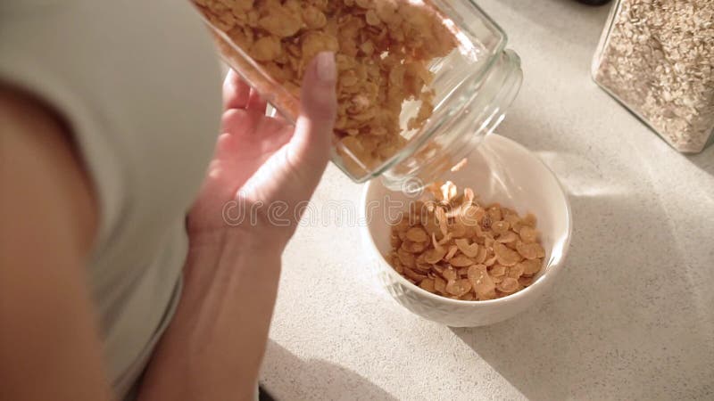Mains saines de femme de petit déjeuner remplissant cuvette par des céréales Muesli clips vidéos