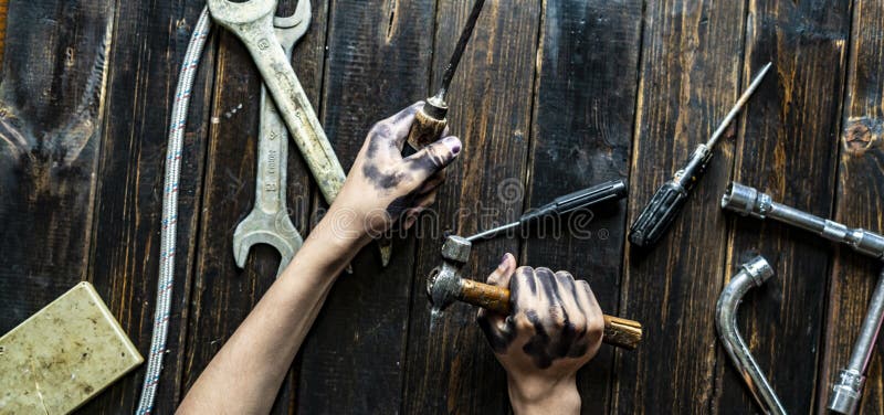 Mains sales foncées d'homme tenant les outils de travail professionnels f image libre de droits Mains sales foncées d'homme tenant les outils de travail professionnels f image libre de droits