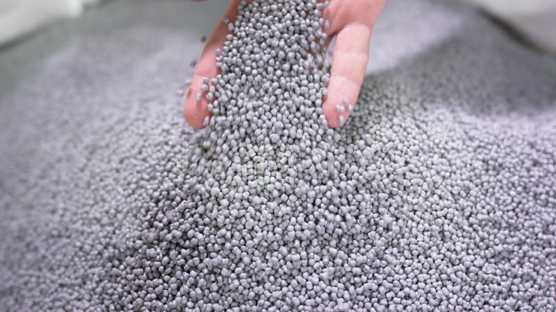 Mains soulever des granules de polymère à partir d'un sac dans une usine de recyclage des ordures. clips vidéos