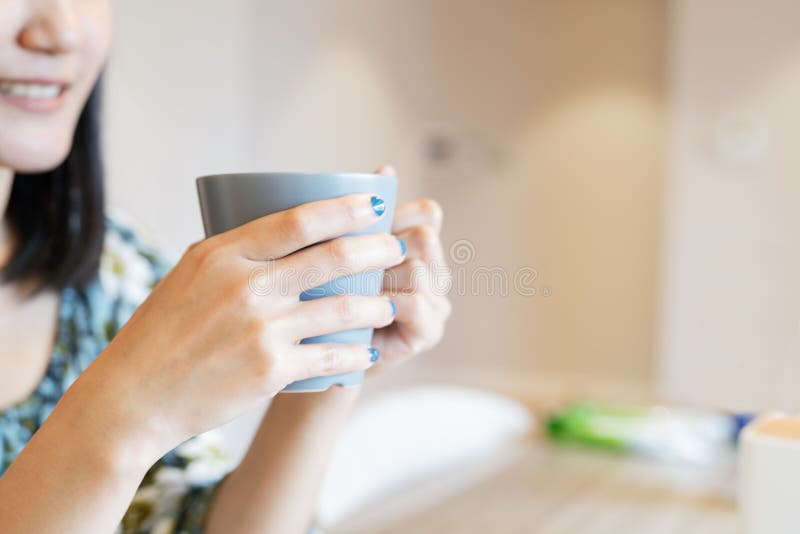 Mains tenant la tasse chaude de café ou de thé à la lumière du soleil de matin photographie stock libre de droits Mains tenant la tasse chaude de café ou de thé à la lumière du soleil de matin photographie stock libre de droits