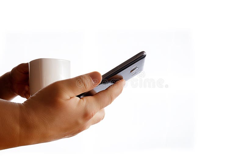 Mains tenant la tasse de téléphone portable et de café photographie stock Mains tenant la tasse de téléphone portable et de café photographie stock