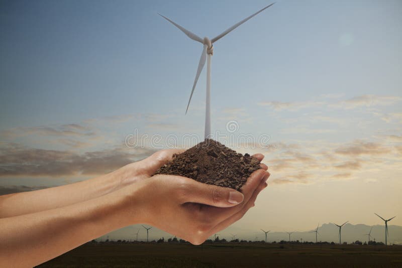 Mains tenant le sol avec une turbine de vent s'élevant du milieu images libres de droits Mains tenant le sol avec une turbine de vent s'élevant du milieu images libres de droits