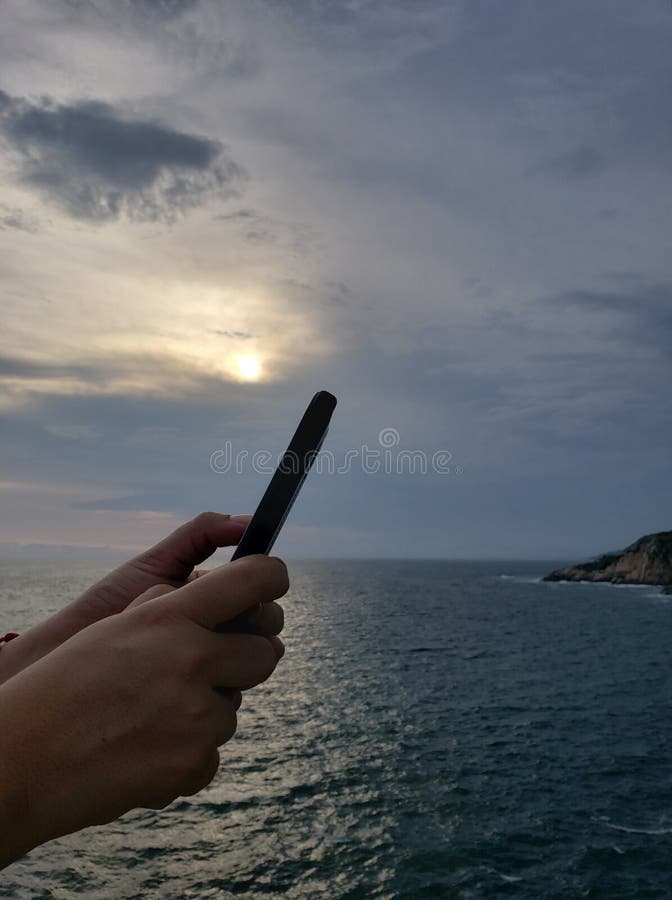 mains tenant un smartphone et un fond avec un paysage tropical photos libres de droits mains tenant un smartphone et un fond avec un paysage tropical photos libres de droits