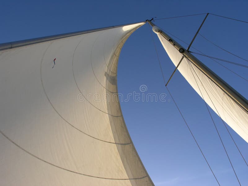 Genoa sail and mainsail filled with wind and a blue sky. Genoa sail and mainsail filled with wind and a blue sky