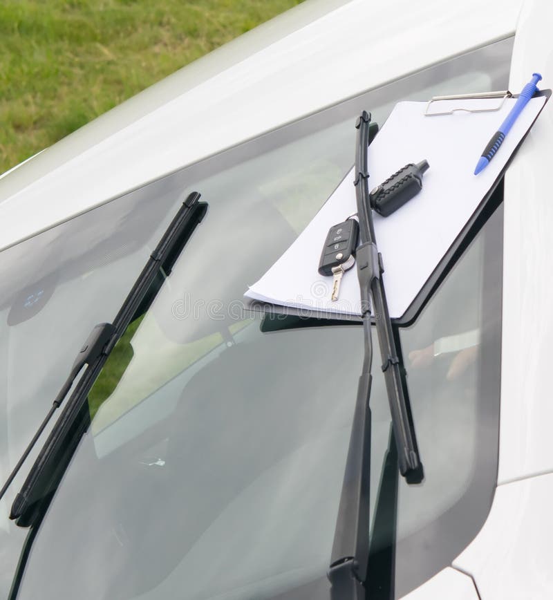 Maintenance documents and car keys, on the windshield of the car royalty free stock photo Maintenance documents and car keys, on the windshield of the car royalty free stock photo