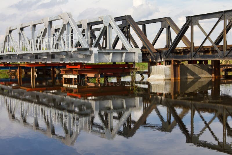 Maintenance of railway bridge, water reflection.