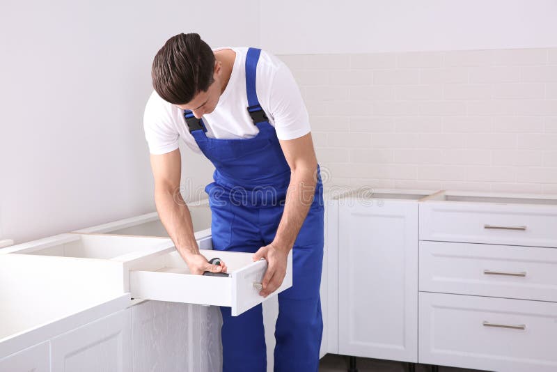 Maintenance Worker Installing New Kitchen Furniture Indoors Stock Photo