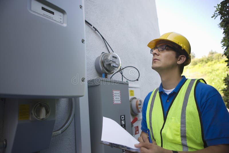 Maintenance Worker Reading Meter Of Solar Generation