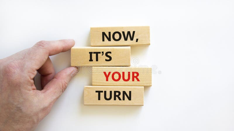 Now, it`s your turn symbol. Wooden blocks form the words `now, it`s your turn` on beautiful white background. Businessman hand. Beautiful background. Business, motivational and your turn concept. Now, it`s your turn symbol. Wooden blocks form the words `now, it`s your turn` on beautiful white background. Businessman hand. Beautiful background. Business, motivational and your turn concept