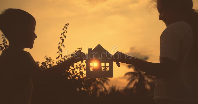 Maison d'achat Dream. Papier maison mains famille soleil brille dans la fenêtre closeup. Maison de papier à main au coucher du sol clips vidéos