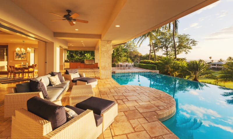 Maison de luxe avec la piscine au coucher du soleil photo stock