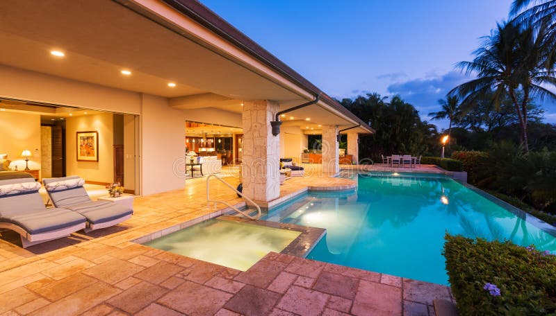 Maison de luxe avec la piscine au coucher du soleil photos stock