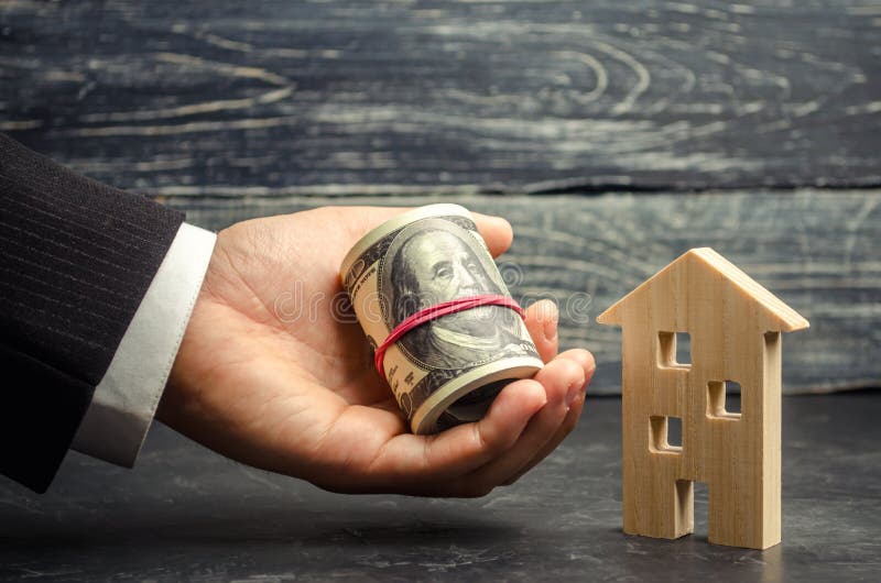 Maison et argent en bois à disposition Un prêt fixé par les immobiliers Rénovation et réparation à la maison Prêts chauds Achetan photos stock