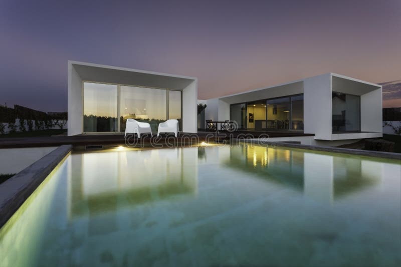 Maison moderne avec la piscine de jardin et la plate-forme en bois images stock