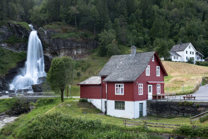 Maison rouge près de cascade de Steinsdalsfossen image libre de droits
