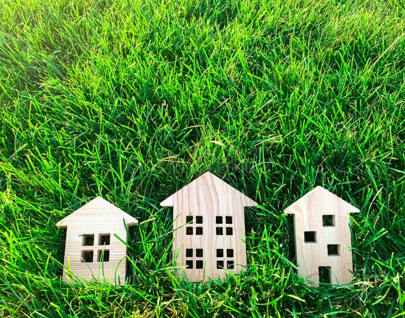 Miniature wooden houses on green grass. Real estate concept. Modern housing. Eco-friendly and energy efficient house. Buying a home outside the city. Nature. Fresh air. Mortgage, loan. Miniature wooden houses on green grass. Real estate concept. Modern housing. Eco-friendly and energy efficient house. Buying a home outside the city. Nature. Fresh air. Mortgage, loan