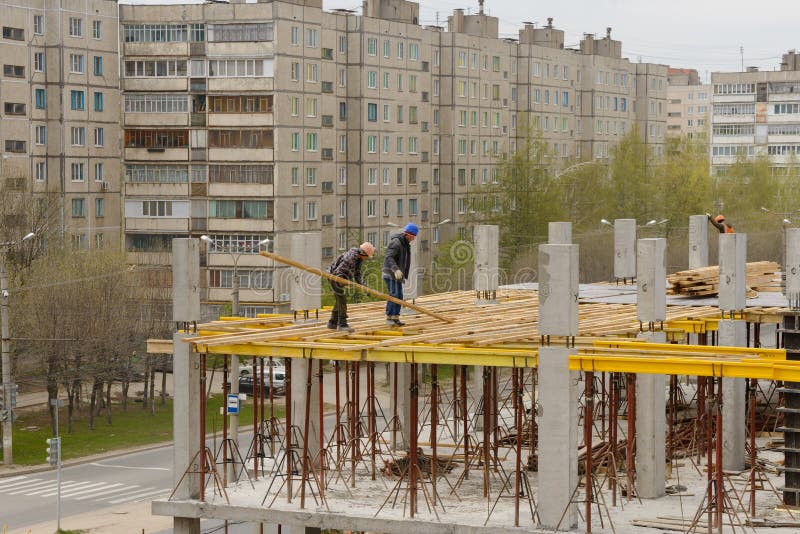 Maj 15, 2017: Byggmästare arbetar på monolitiska arbeten på konstruktionsplatsen av envåning byggnad royaltyfri foto Maj 15, 2017: Byggmästare arbetar på monolitiska arbeten på konstruktionsplatsen av envåning byggnad royaltyfri foto