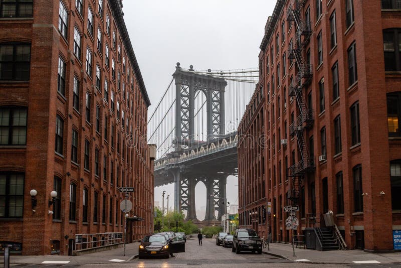 04 2019 Maj - usa, Nowy Jork: Manhattan przerzuca most widzii od czerwonych ceglanych domy w Brooklyn ulicie w perspektywie