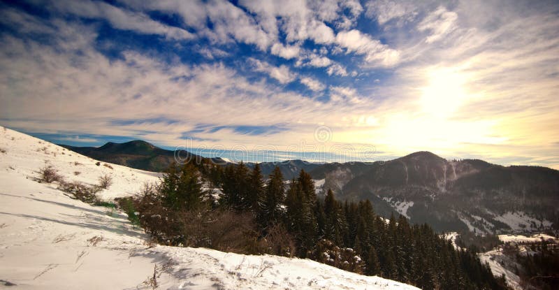 Majestic sunset in the mountains landscape. Sunset landscape in Carpathian mountains. Dawn in mountains Carpathians, Romania. Mountains covered with snow