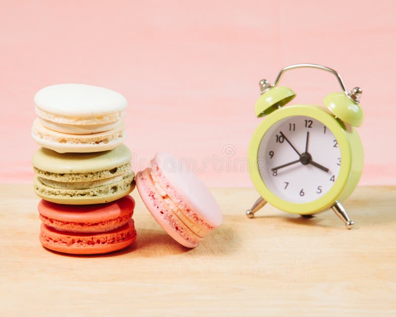 Makarons en wekker op lijst, wijnoogst gestileerde foto stock foto's Makarons en wekker op lijst, wijnoogst gestileerde foto stock foto's