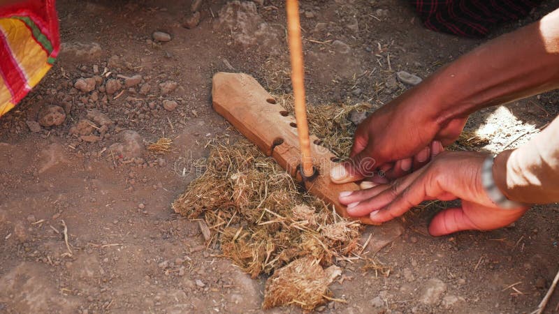 Production of fire in traditional way hand drill friction sticks African Tribes