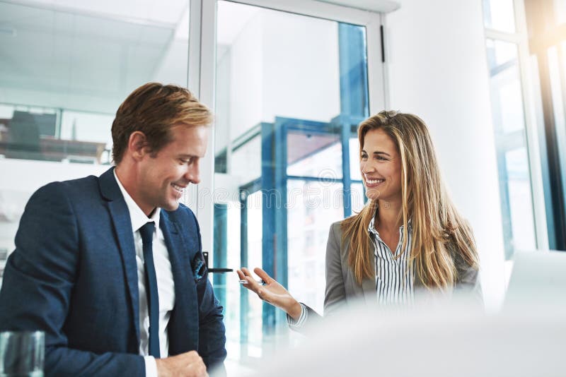 They make great things happen. two businesspeople having a discussion in the office. stock photography