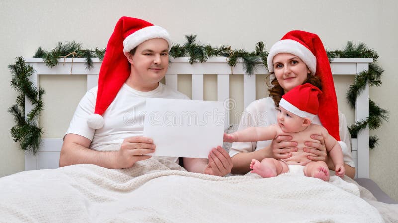 Make och maka med papper på sängbeklädnad för julklappar royaltyfri fotografi