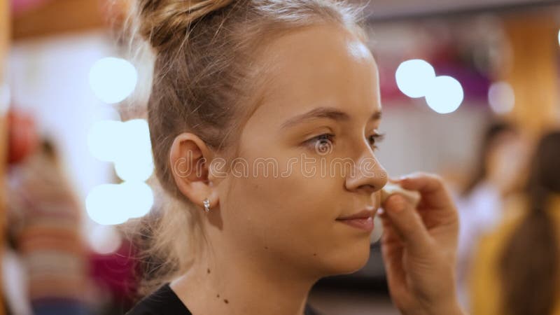 Make-up artist apply makeup on girl modelling for a class - closeup