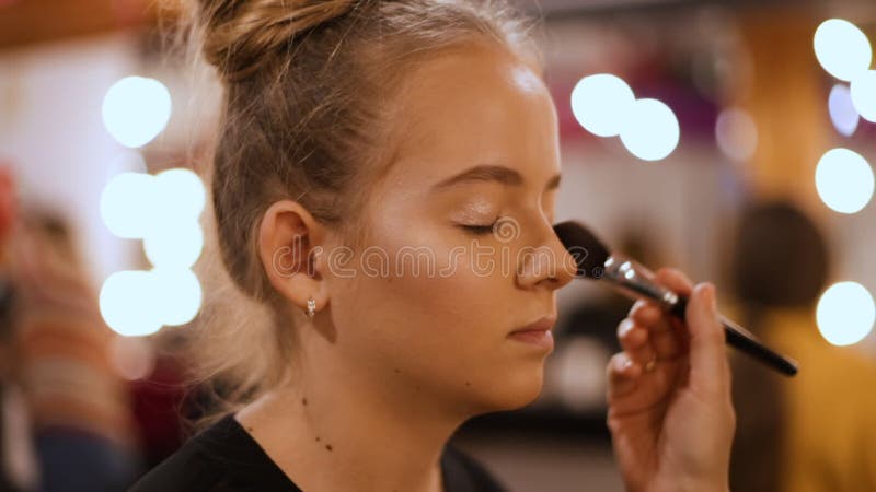 Make-up artist apply makeup with large brush - closeup