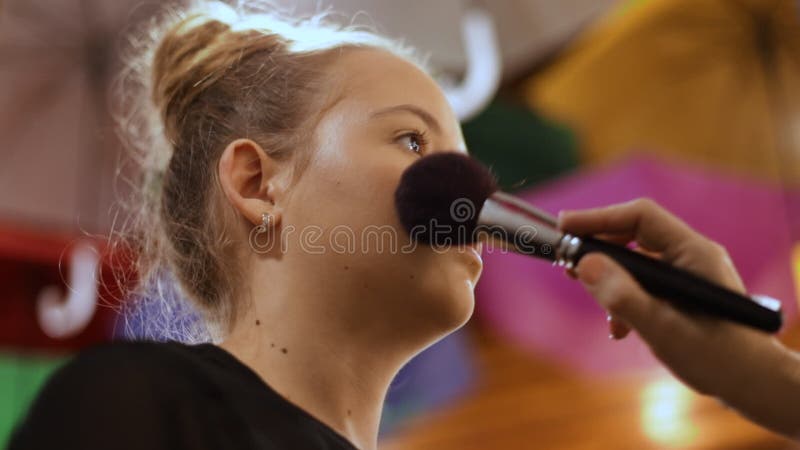 Make-up artist apply makeup with large brush - closeup