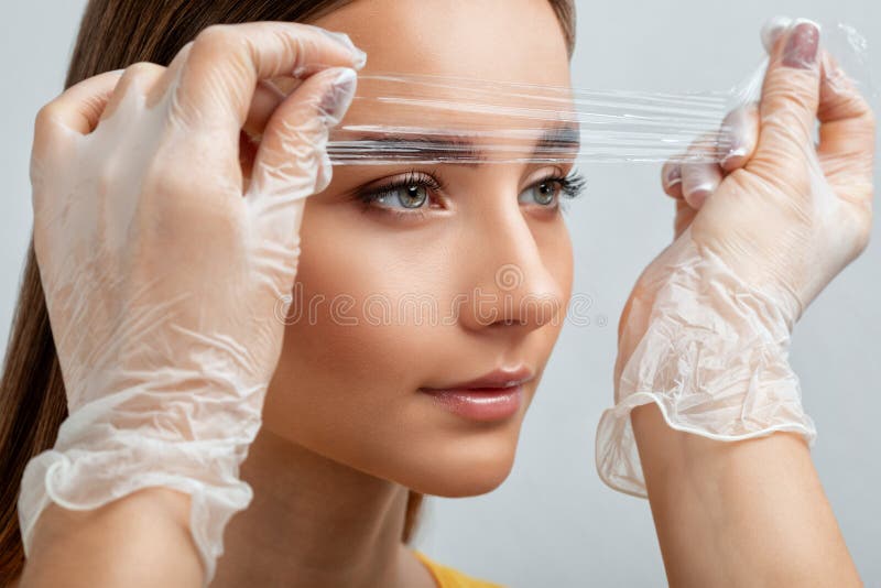 The Makeup Artist Does Longlasting Styling of the Eyebrows of the Eyebrows and Will Color the