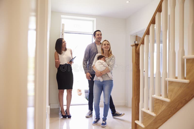 Makelaar in onroerend goed die Jonge Familie tonen rond Bezit voor Verkoop stock foto Makelaar in onroerend goed die Jonge Familie tonen rond Bezit voor Verkoop stock foto