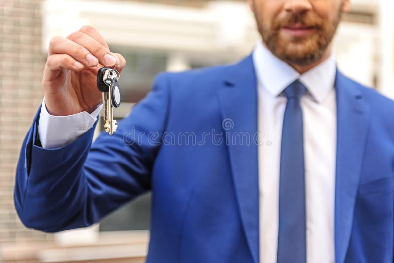 Makelaar in onroerend goed met sleutels tot het huis royalty-vrije stock foto Makelaar in onroerend goed met sleutels tot het huis royalty-vrije stock foto